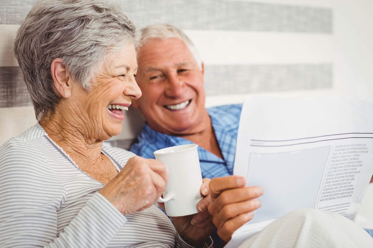 senior couple in bed enjoying morning coffee ritual