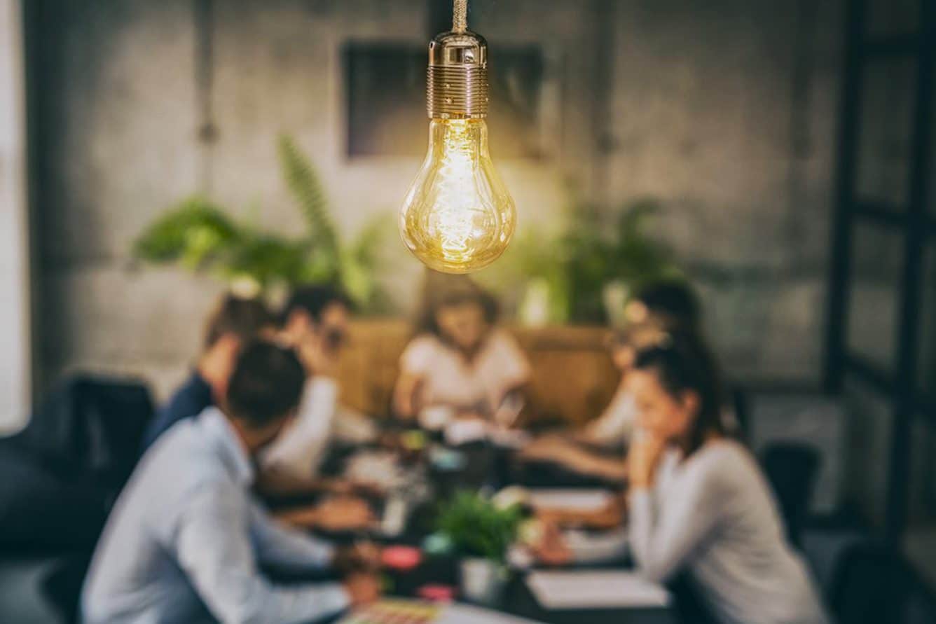 A glowing light bulb with group of people